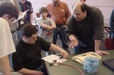 Joe (right) instructing Brian (sitting) on how to open a servo