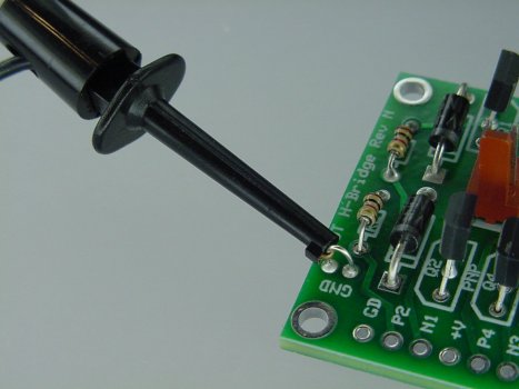 A multimeter test probe hook firmly attaches to a loop of wire.