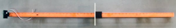 A plastic level with a slide for measuring distances using an infrared electronic sensor.