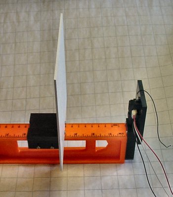An optical target that slides and a sensor attached to the end of a level.