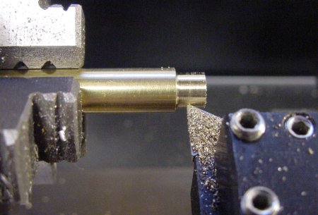 Turning down the diameter of a brass rod in a lathe.