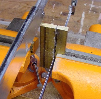 Cutting brass stock with a hacksaw.