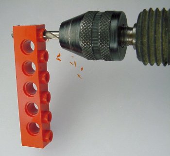 Drilling a hole in the end of a Lego Technic beam.