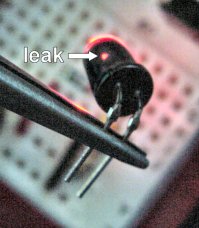 An infrared emitter/LED coated in black paint to prevent side leakage has an uncovered spot.