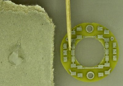 A thin line of silicone adhesive applied with a toothpick to bare spots on the PCB.