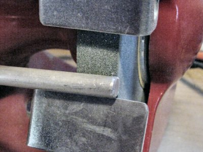 Grinding down the diameter of an aluminum rod.