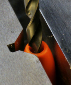 V groove holds banana cover while enlarging hole for lower gage wire
