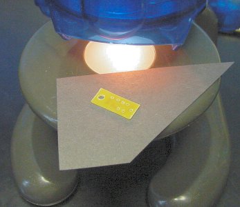 Thin, light-colored (and tiny) circuit board placed on black construction paper