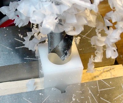 Drilling a large hole in the center of a plastic block to insert a motor.