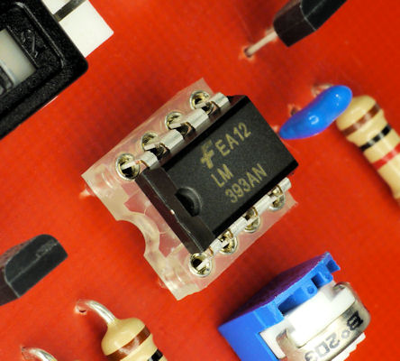 Chip in clear socket on red printed circuit board