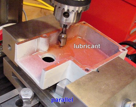 The gearbox cover raised up in a vise for drilling.