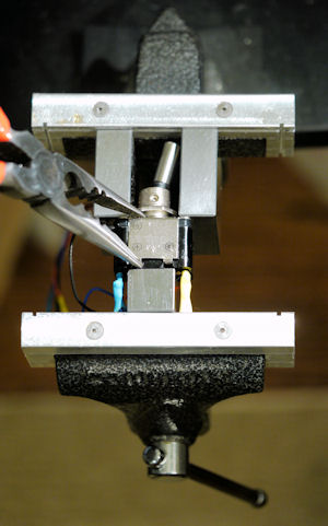 Putting a toggle switch back together using a vise and blocks