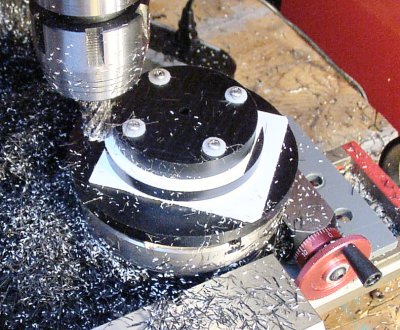 Milling three discs at the same time by stacking them in order of diameter on a rotary table.