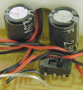 A pair of 1F 2.5WV ultracapacitors and a DPDT dark-line / light-line selection switch on the underside of the Chicago solar-powered line-following miniature robot.