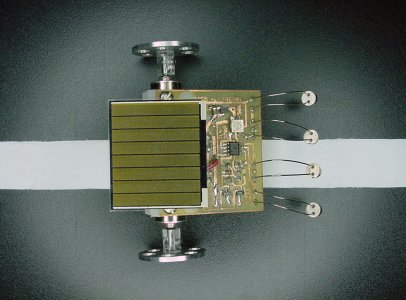 Chicago miniature solar-powered robot following a line on a ChiBots robot club standard line-following tile.