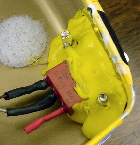 Screws grip quite effectively on unthreaded holes in hot melt glue, firmly holding the tailpipe switch in place on the Sweet line-following robot.