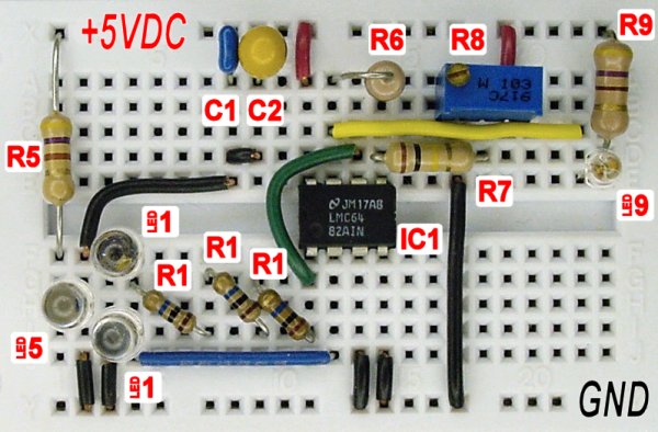 Solderless breadboard with a pair of reversed LEDs and a low-input current op amp to act as a color sensor.