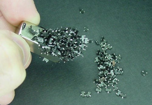 A large neodymium rare-earth magnet easily transports a pile of SOT-23 transistors.