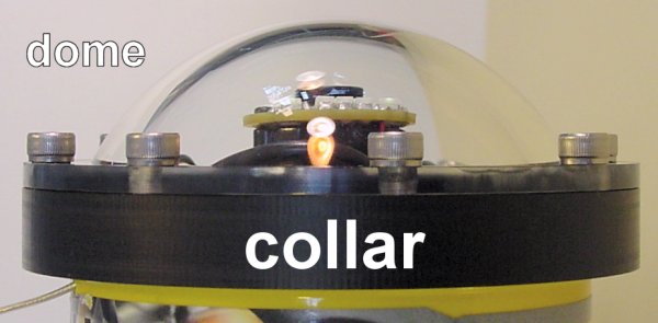 A clear acrylic dome bolted onto a black plastic collar on a robot&rsquo;s body.