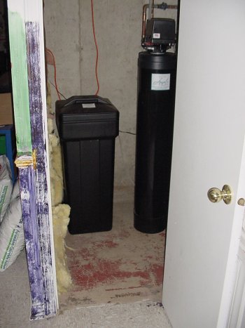 Brine tank and water softener in a basement closet.